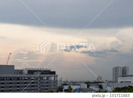a cityscape featuring various modern buildings and other structures, including a prominent construction crane. The atmosphere appears gloomy due to the heavy, overcast clouds that fill the sky, which a cityscape featuring various modern buildings and other structures, including a prominent construction crane. The atmosphere appears gloomy due to the heavy, overcast clouds that fill the sky, which 131711883