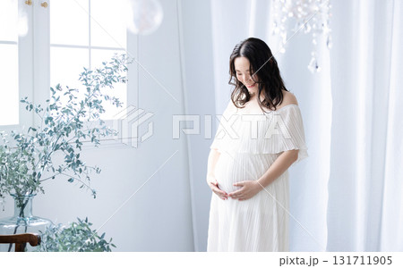 窓際に立つ妊婦さん 131711905