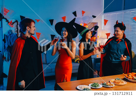Joyful office Halloween party with coworkers in costumes, celebrating with drinks and laughter, fostering teamwork and festive spirit 131712911