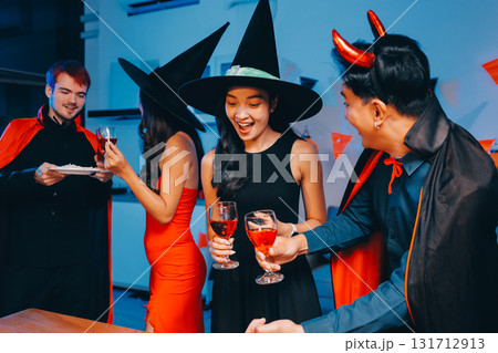 Joyful office Halloween party with coworkers in costumes, celebrating with drinks and laughter, fostering teamwork and festive spirit 131712913