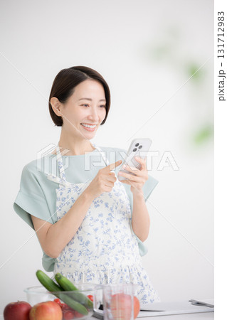 キッチンでレシピを探す主婦のイメージ キッチンでレシピを探す主婦のイメージ 131712983