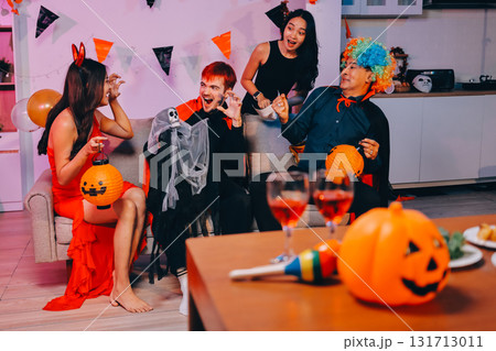 Joyful office Halloween party with coworkers in costumes, celebrating with drinks and laughter, fostering teamwork and festive spirit 131713011