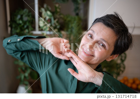 Smiling elderly woman dance playfully at home, look at camera in joyful expression. Natural beauty Smiling elderly woman dance playfully at home, look at camera in joyful expression. Natural beauty 131714718
