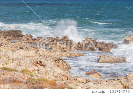 Powerful surf hitting rocks emerald blue sea white foam and clear sky. Powerful surf hitting rocks emerald blue sea white foam and clear sky. 131714779