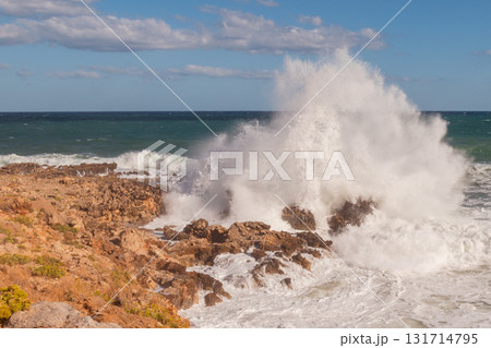 Stormy seascape with waves crashing against rocky shore and high white foam splashes. Stormy seascape with waves crashing against rocky shore and high white foam splashes. 131714795