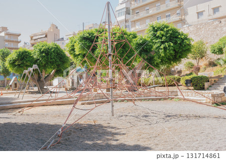 Playground climbing structure in city park shaped like pyramid. 131714861