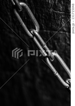 The alloy steel chain shines against a dark background 131715048