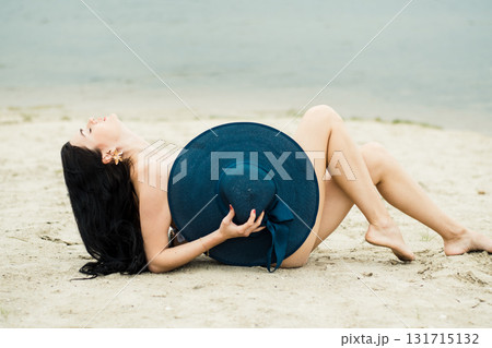 The young lady is lying on the golden coast among the soft sand 131715132