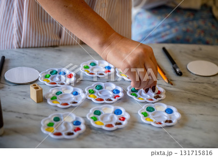 Colorful paint palettes with brushes and pencils on marble table ready for art activity Colorful paint palettes with brushes and pencils on marble table ready for art activity 131715816