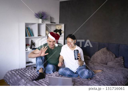 a senior woman and young man congratulate everyone on Christmas via the Internet, video conference, celebration at home 131716061
