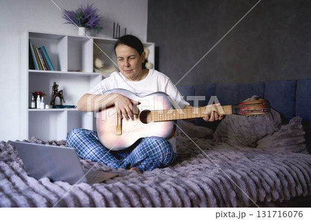 a senior woman learns to play the guitar with online lessons a senior woman learns to play the guitar with online lessons 131716076
