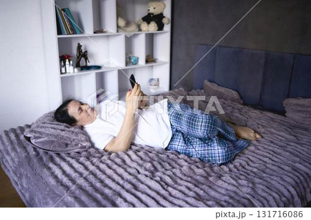 a senior woman chatting on the phone in bed 131716086