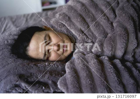 a senior woman sleeping under a weighted blanket a senior woman sleeping under a weighted blanket 131716097
