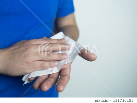 A man suffers from palmar hyperhidrosis. He wipes his sweaty palms due to excessive sweating. Treatment of hyperhidrosis with botulinum toxin injection into the hand. A man suffers from palmar hyperhidrosis. He wipes his sweaty palms due to excessive sweating. Treatment of hyperhidrosis with botulinum toxin injection into the hand. 131716183