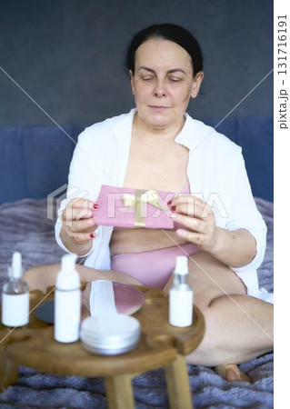 a senior woman in underwear with gold glitter on her face and hands holding a gift certificate a senior woman in underwear with gold glitter on her face and hands holding a gift certificate 131716191