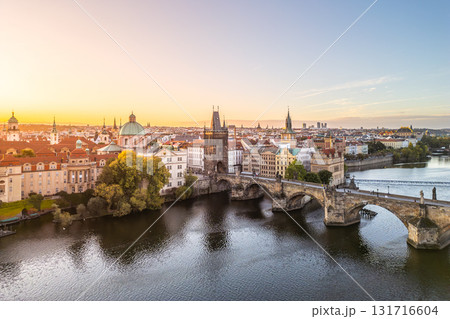 Stunning view of Old Town Bridge Tower at Charles Bridge during sunset. The serene Vltava River reflects the historic architecture of Prague, creating a picturesque scene. Stunning view of Old Town Bridge Tower at Charles Bridge during sunset. The serene Vltava River reflects the historic architecture of Prague, creating a picturesque scene. 131716604