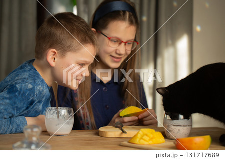 Children smile watching black cat drink chia dessert Children smile watching black cat drink chia dessert 131717689