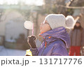 Child blowing bubbles in frosty sunshine 131717776