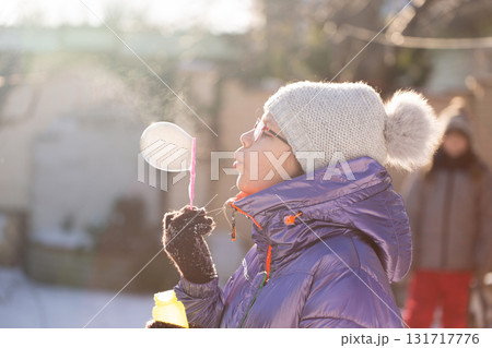 Child blowing bubbles in frosty sunshine Child blowing bubbles in frosty sunshine 131717776