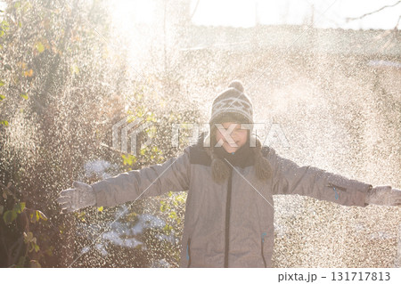 Happy boy playing in flying winter snow outdoors 131717813