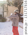 Boy playing snowball fight outdoors on sunny winter day 131717816