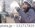 Smiling boy playing with snow in winter sunlight outdoors 131717820