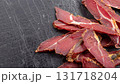 The of amacro photo of dried sliced lamb basturma on black marble surface top view 131718204