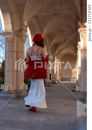 Woman Beret Arcade walking outdoors on sunny day for leisurely stroll. 131718365