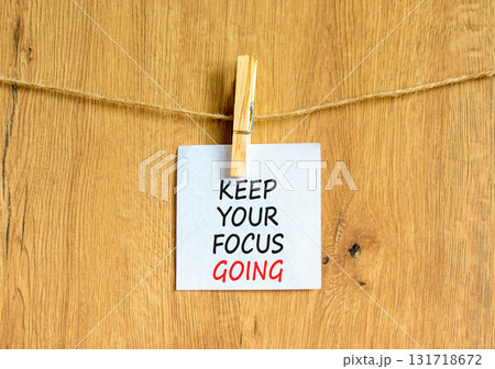 Keep your focus going symbol. Concept words Keep your focus going on beautiful white paper on clothespin. Beautiful wooden background. Business and keep your focus going concept. Copy space. Keep your focus going symbol. Concept words Keep your focus going on beautiful white paper on clothespin. Beautiful wooden background. Business and keep your focus going concept. Copy space. 131718672