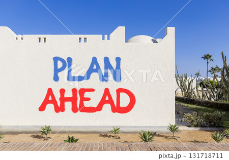 Plan ahead symbol. Concept word Plan ahead on beautiful white wall. Beautiful blue sky background. Business plan ahead concept. Copy space. 131718711