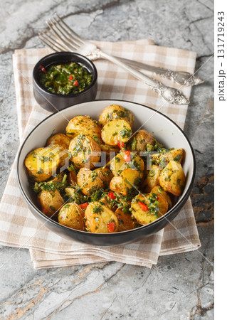 Baked new potatoes served with freshly made chimichurri sauce close-up in a bowl. Vertical 131719243