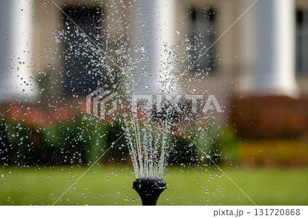 fountain splash close-up on a defocused background of an old manor, selective focus 131720868