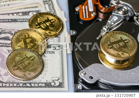 Bitcoin BTC coins, open hard drive and dollar bills, digital payment system concept Bitcoin BTC coins, open hard drive and dollar bills, digital payment system concept 131720907