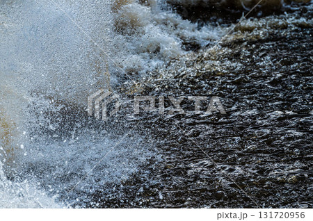 close up of flowing water, rapid water splashes of an white water river or stream, bubbly water 131720956