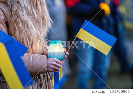 Ukrainian flags, candles and torches in the hands of protesters at the rally "Stand With Ukraine", closeup 131720966