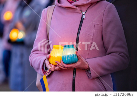 Ukrainian flags, candles and torches in the hands of protesters at the rally "Stand With Ukraine", closeup Ukrainian flags, candles and torches in the hands of protesters at the rally "Stand With Ukraine", closeup 131720968