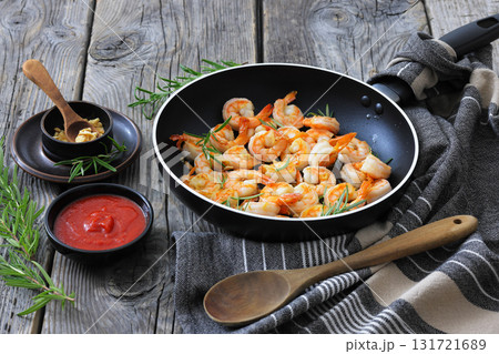 rosemary and garlic seared shrimps in a skillet rosemary and garlic seared shrimps in a skillet 131721689