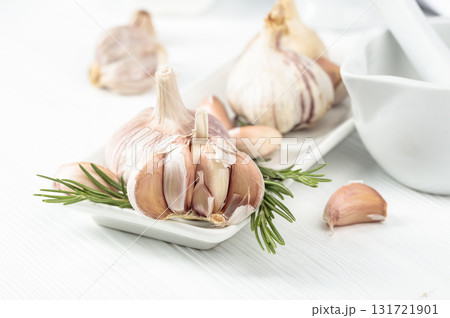Fresh garlic bulbs with rosemary. 131721901