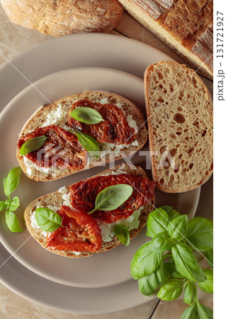 Ciabatta with sun dried tomatoes in olive oil, creamy cheese, and basil. 131721927
