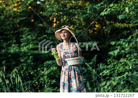 A lady in a hat stands on the grass A lady in a hat stands on the grass 131722207