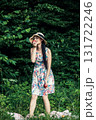 A woman in a floral dress holds two red apples 131722246