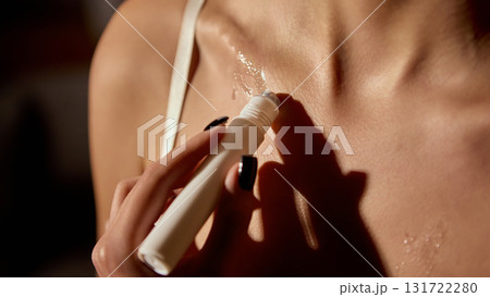 Woman applying skincare serum roller on collarbone for body hydration Woman applying skincare serum roller on collarbone for body hydration 131722280