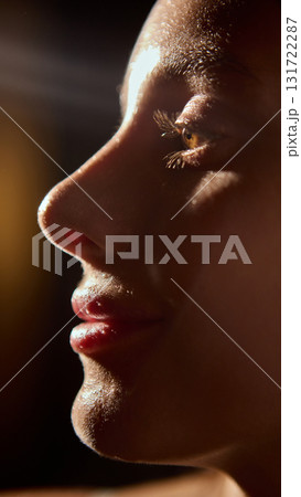 Female face profile in warm light with glowing skin and long eyelashes 131722287