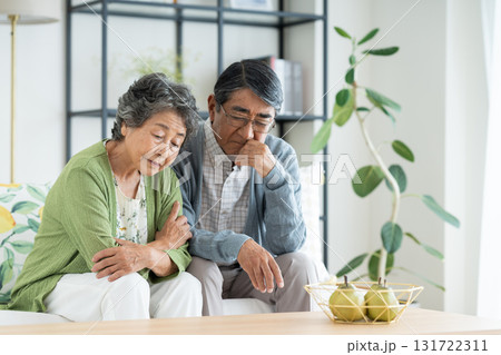 リビングで悩むシニアの夫婦 131722311