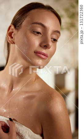 Woman with wet glowing skin wrapped in towel after shower symbolizing freshness and skincare Woman with wet glowing skin wrapped in towel after shower symbolizing freshness and skincare 131722360