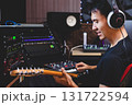 smiling asian male music producer, musician, guitarist, artist playing and recording electric guitar in home studio. recording concept 131722594
