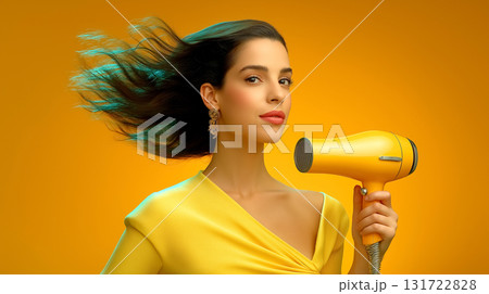 Woman styled in elegant yellow outfit holds bright yellow hair dryer, poised and confident with hair flowing. Minimalist backdrop adds focus. Concept of beauty, hair care, salon services. 131722828