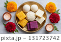 Traditional Indian food featuring an array of sweets including ladoo and jalebi presented on a decorative plate 131723742