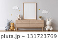 Blank frame for wall art mockup in a modern nursery featuring wooden dresser and beige wall. Soft plush toys sit beside the frame, adding a cozy atmosphere to the space. 131723769