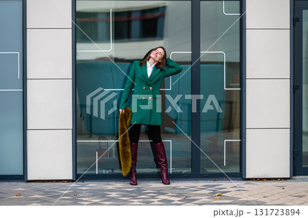 portrait of an elegantly dressed business woman at a glazed building in a financial district 131723894